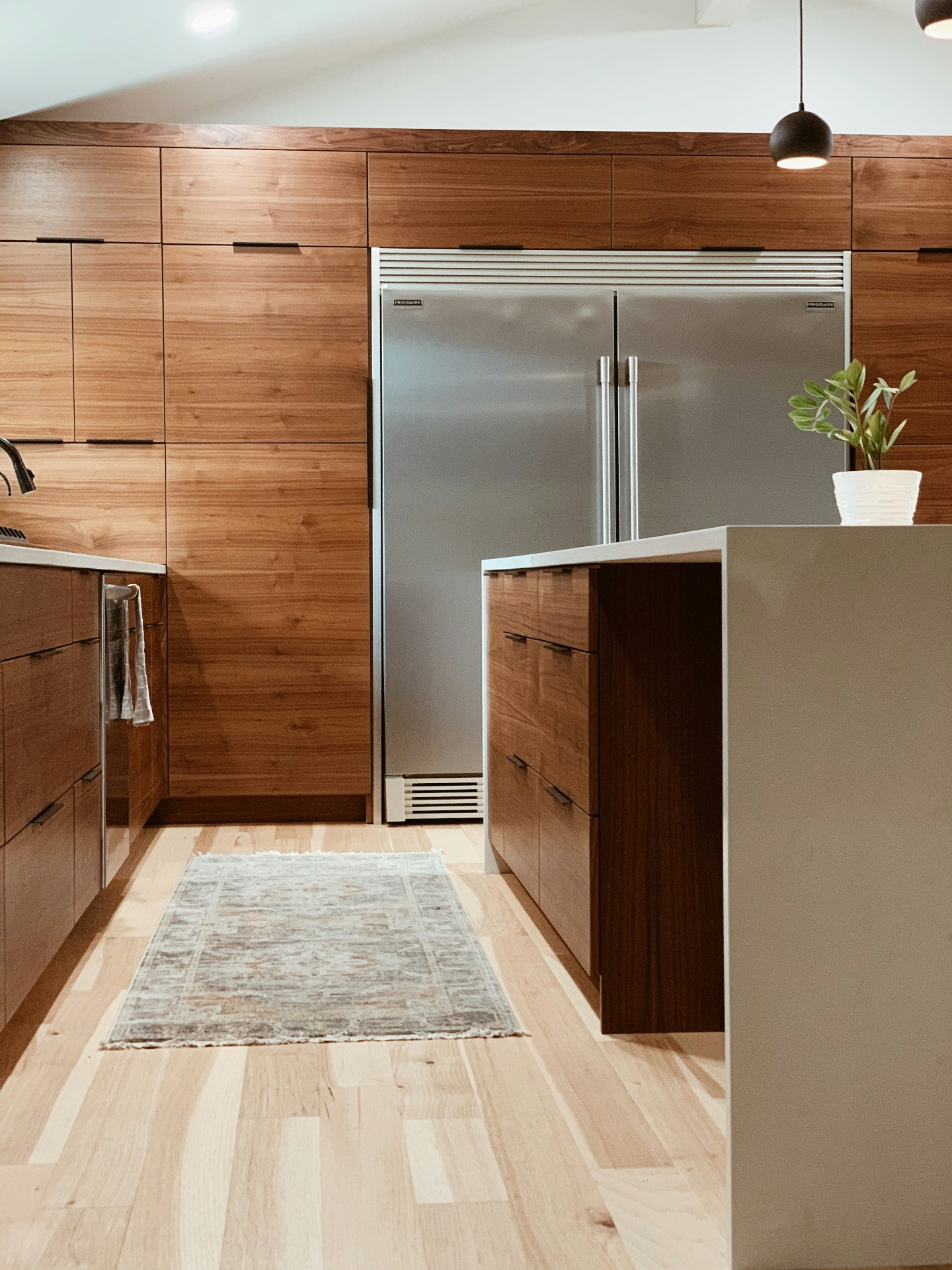 Custom walnut kitchen cabinetry with integrated refrigerator